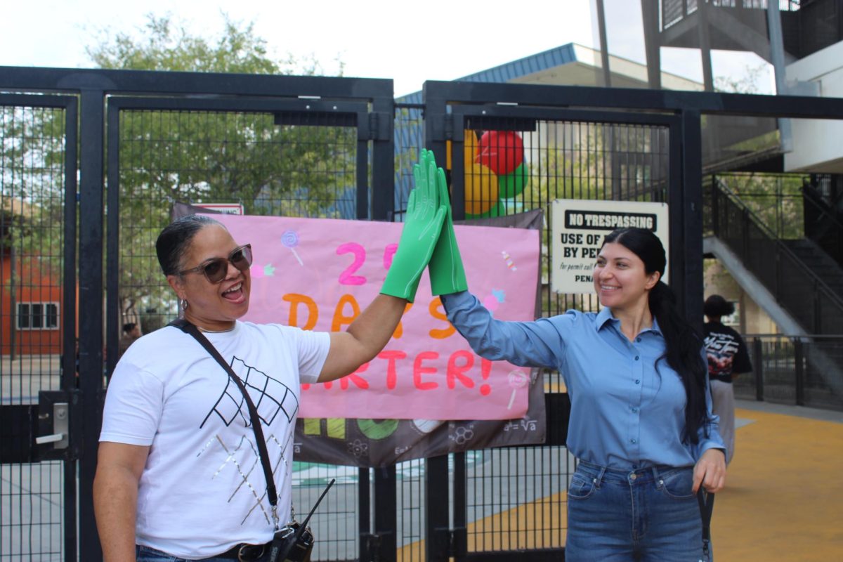 Ms.Pam [PSA} and Ms. Anderson [assistant principal] celebrate 25 days of attendance at Hawkins HS. They were happily working together wearing funny looking green gloves to make the student  laugh and create joy. 

Credit for photographer  Genesis Hernandez 