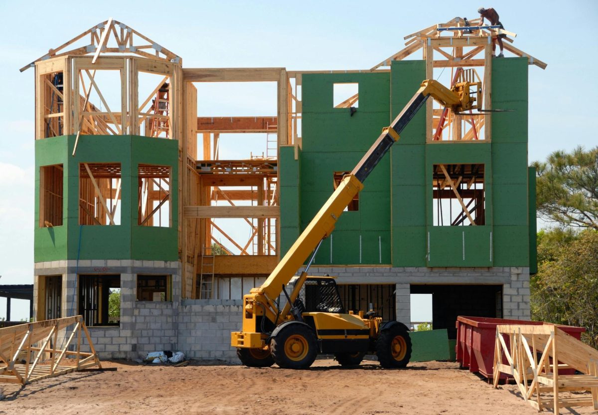 Photograph of an unfinished building at a construction site with a yellow and black heavy equipment nearby. This is what Los Angeles should look like throughout the county.